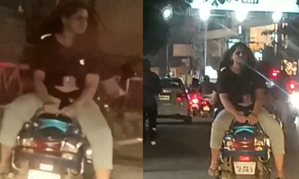 Woman sitting backwards on the back seat of a scooter