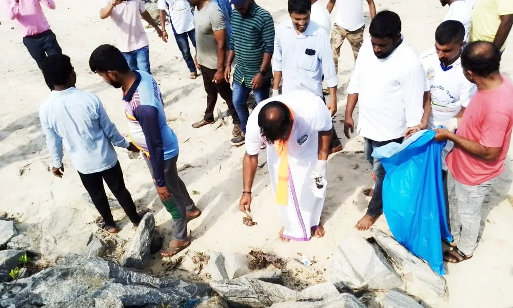Gururaj gantihole and other activists cleaning in someshwara beach 