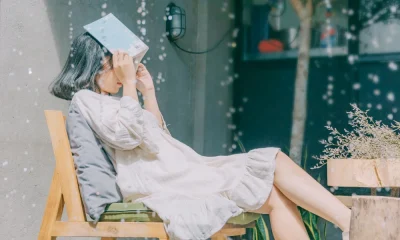 Girl sitiing in chair at home with book when Rain is coming