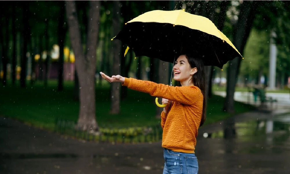 Woman with umbrella enjoys rain