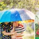 Boy and girl standing outdoors in rainy day under colourful umbrella and lalbagh flower show