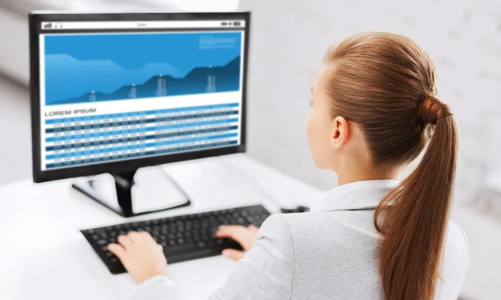 Businesswoman with Graphs on Computer at Office