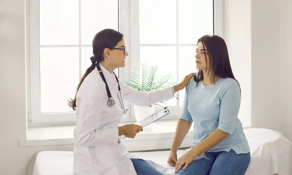 Doctor Reassuring and Supporting Young Woman While Talking to Her about Her Health Issues
