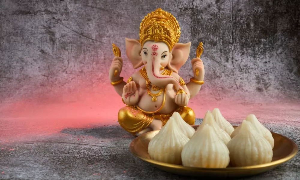 Idol of Lord Ganesha with Modak Sweet Dish and Flower. Ganesh Chaturthi