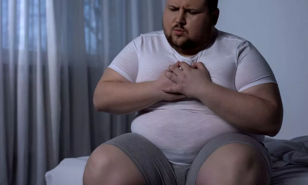 Overweight man suffering from chest pain, high blood pressure, cholesterol level