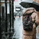Woman Walking on Street Under Black Umbrella rain news