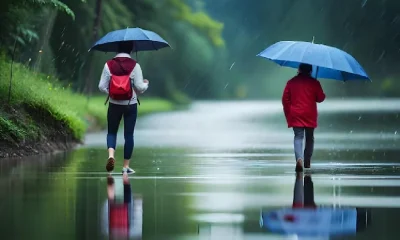 Boy and girl walking in road with rain