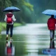 Boy and girl walking in road with rain
