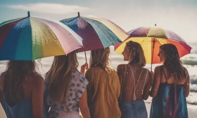 Girls are standing in beach with umbrealla