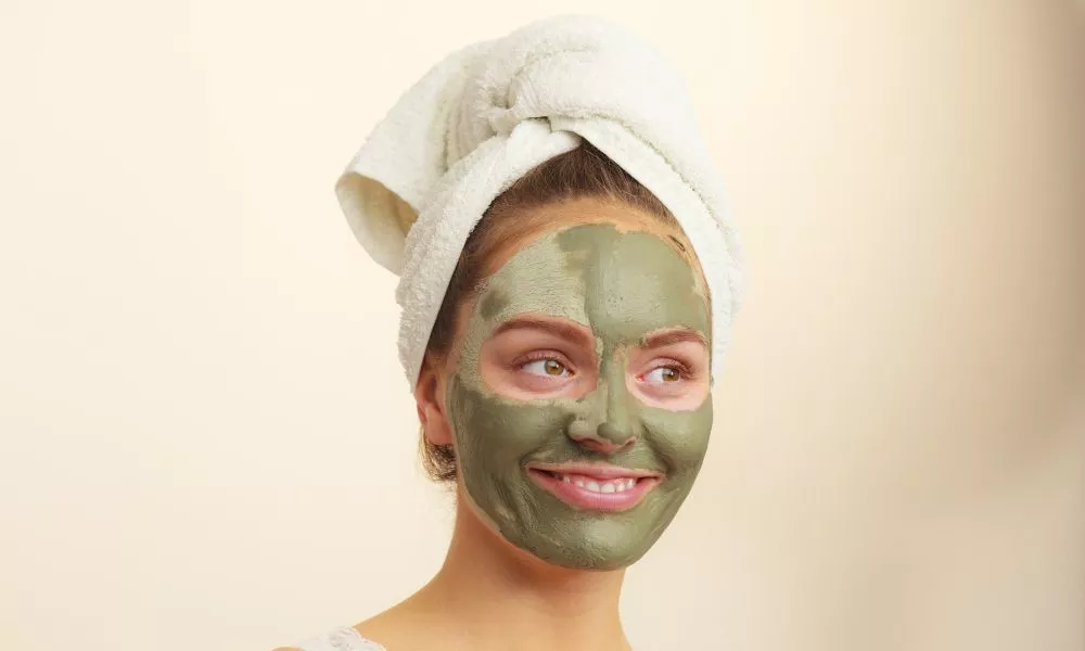 Woman face with green clay mud mask