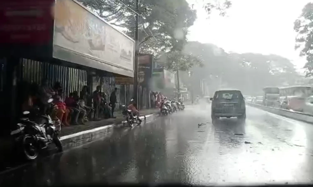 Bengaluru Rain people standing in bus stop