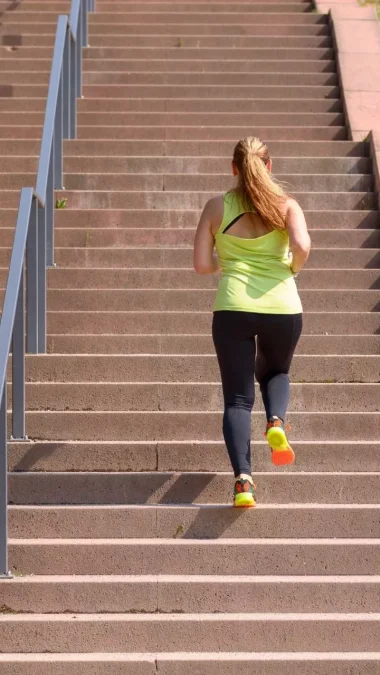 Woman running while climbing stairs during workout Climbing Stairs Benefits