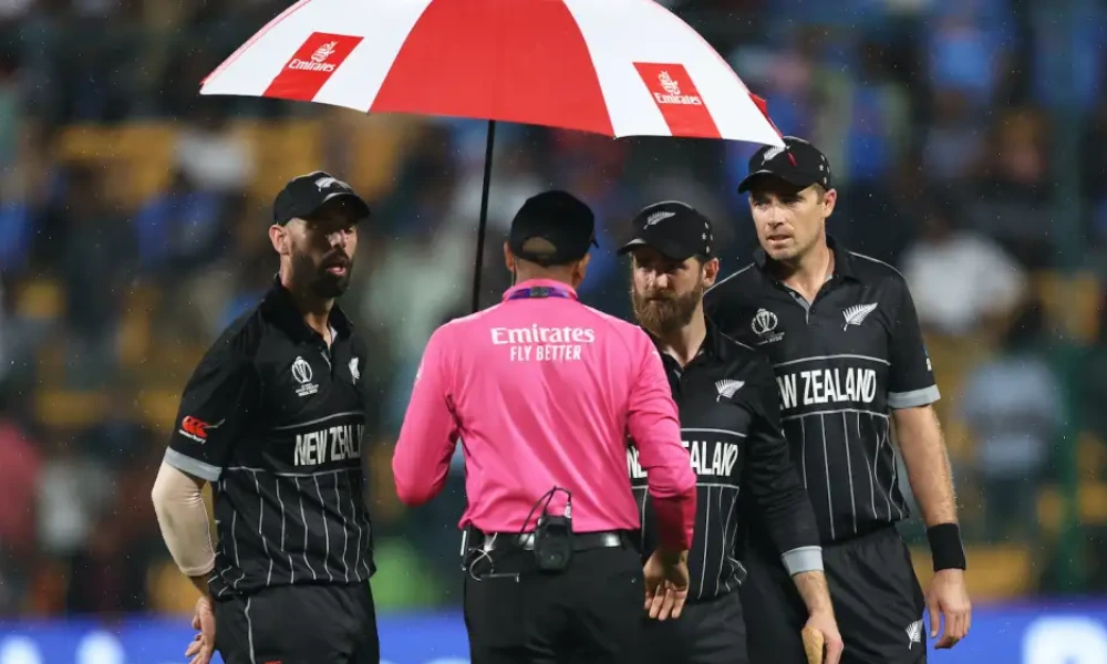 Daryl Mitchell, Kane Williamson, and Tim Southee talk to an official at the second rain break
