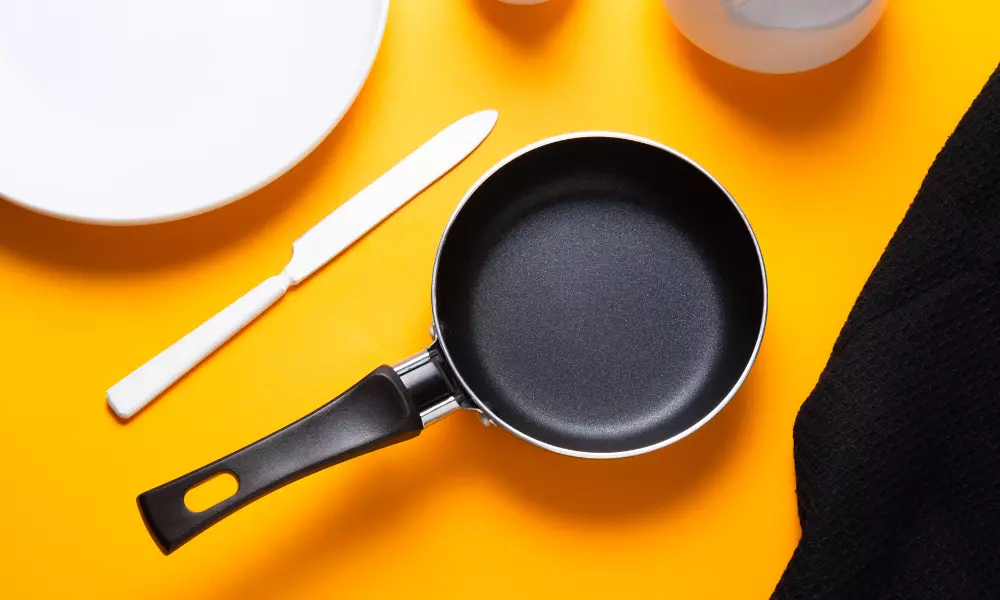 Black Metal Nonstick Frying Pan, on Yellow Background