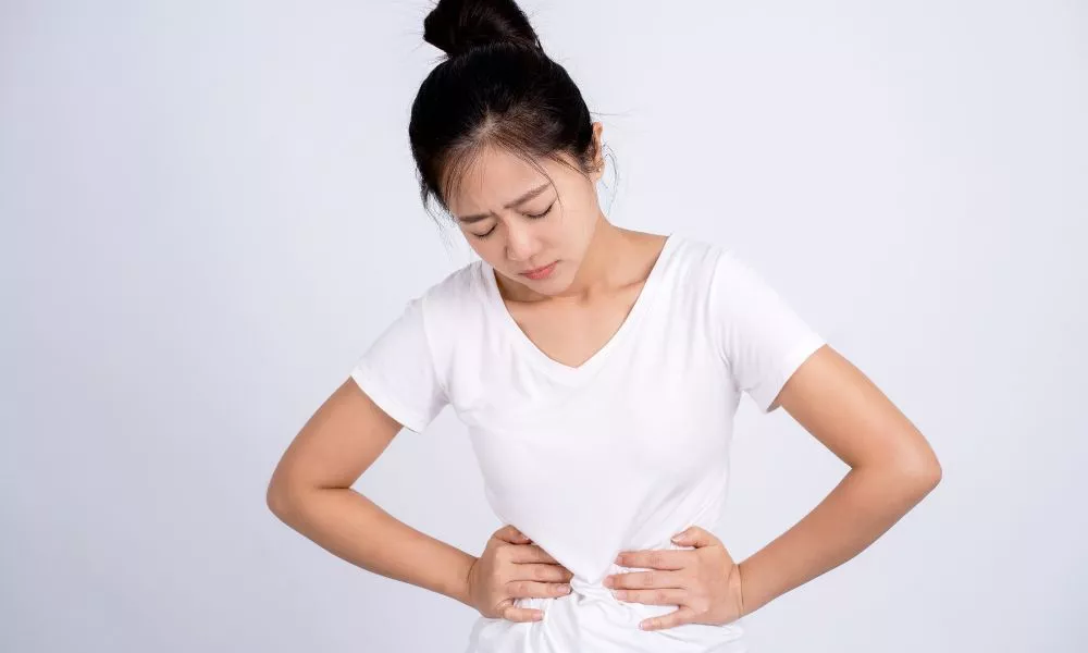 Woman Has Stomach Pain on White Background.