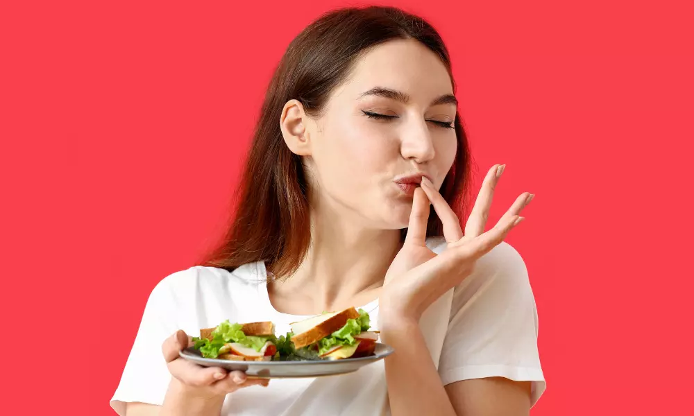 Young Woman Eating Tasty Sandwich on Color Background