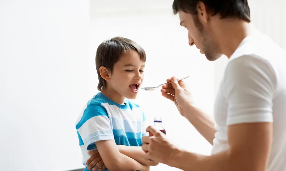 Father Giving Son Cough Syrup