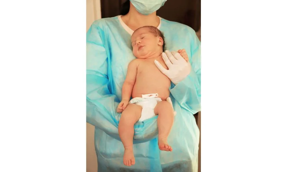 Doctor Holding Cute Newborn Child in Hospital