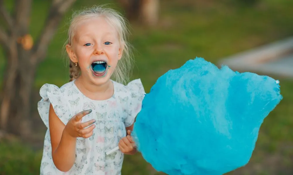 Little Blond Girl Eating Cotton Candy
