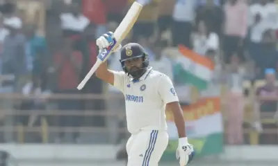 Rohit Sharma raises his bat after scoring a hundred