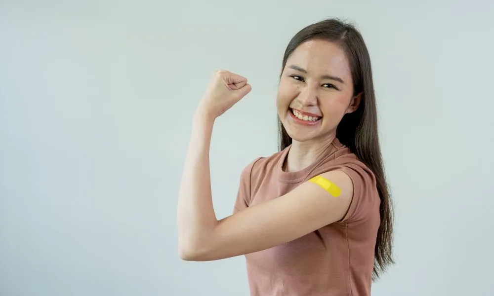 Asian woman smiling brightly happy vaccination Show arms wit