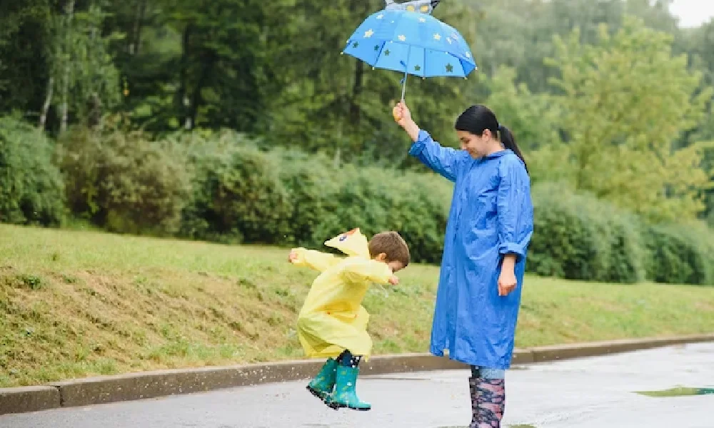 Women and her daughter play with rainy water