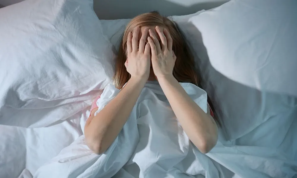 Scared Woman Lying in Bed at Home