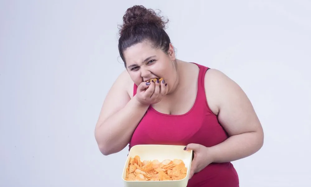 obese woman eating chips