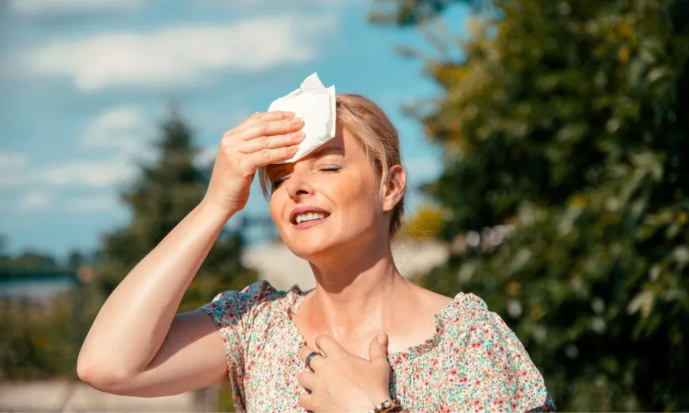 Woman having hot flashes and sweats
