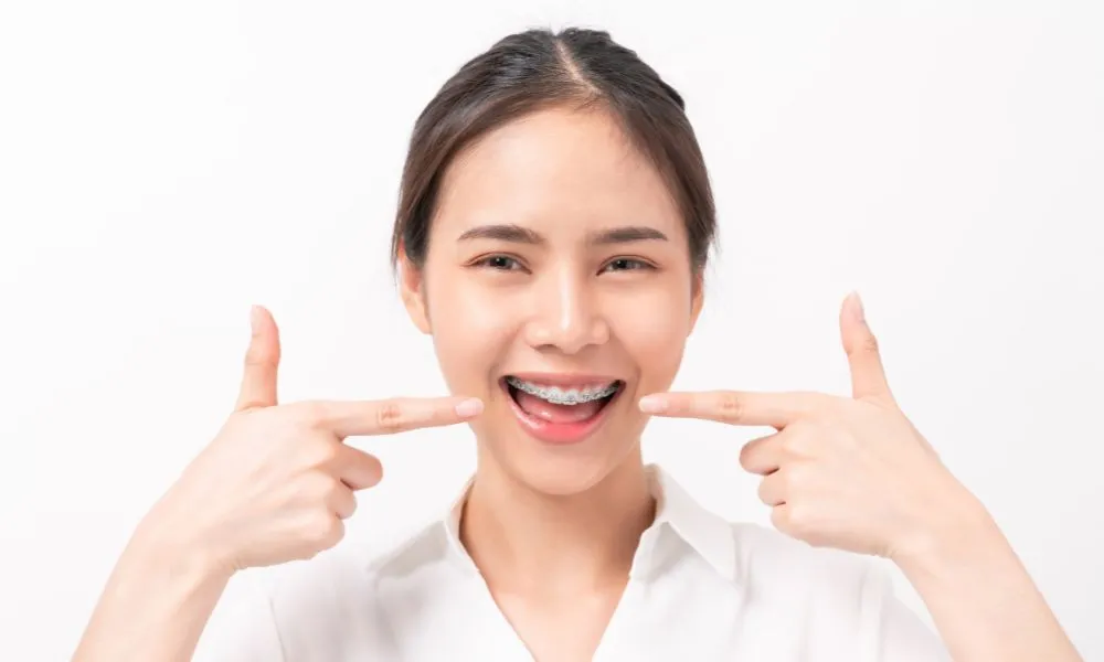 Young Woman Pointing at Her Braces 