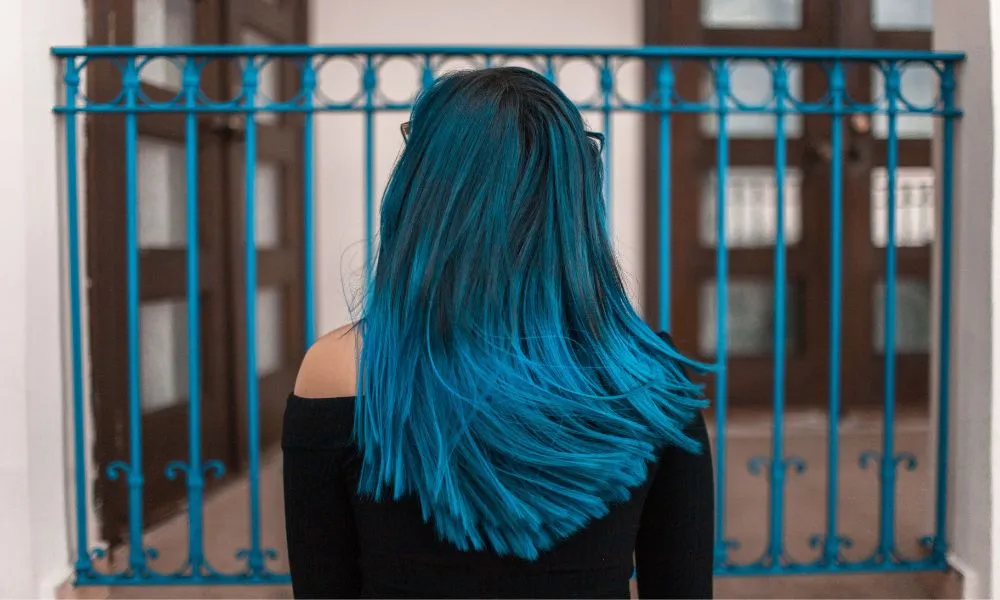 Blue Haired Woman Facing Metal Fence