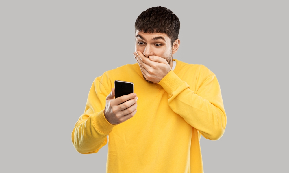 Shocked Young Man with Smartphone