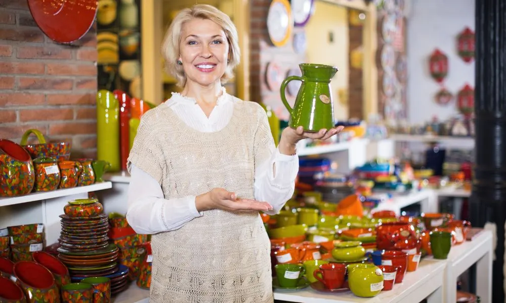 Female shopping ceramic cookware at workshop