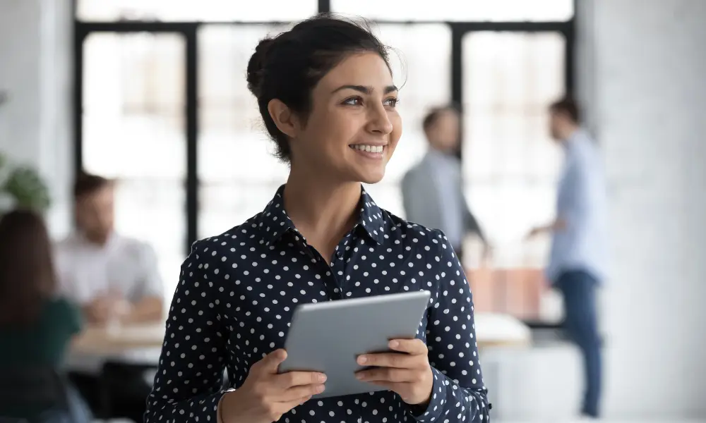 Young indian female employee look in distance planning